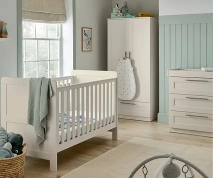 White nursery room furniture including cot, wardrobe and changing station